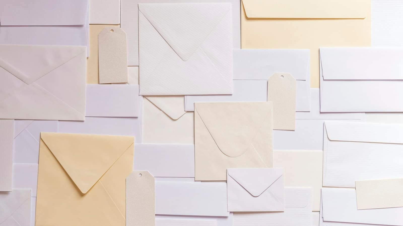 A pile of plain white and cream envelopes and paper tags