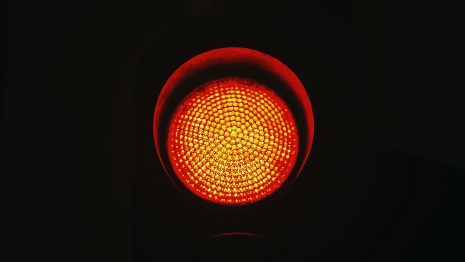 A round red traffic light glowing against a black background