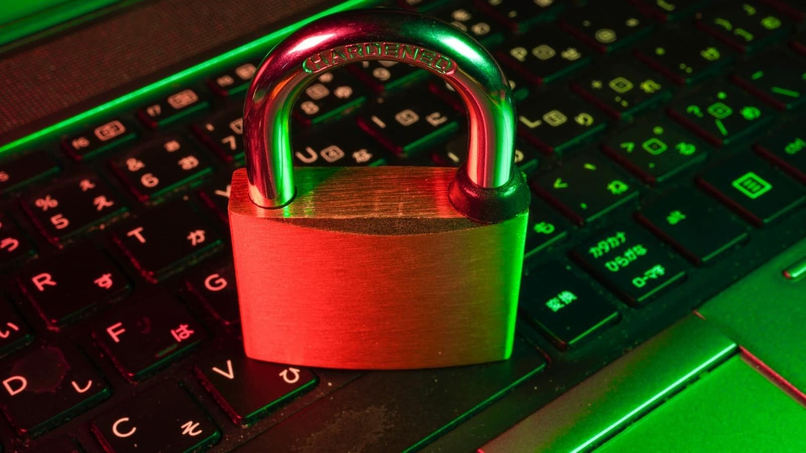 A red padlock sitting on a laptop keyboard lit in green