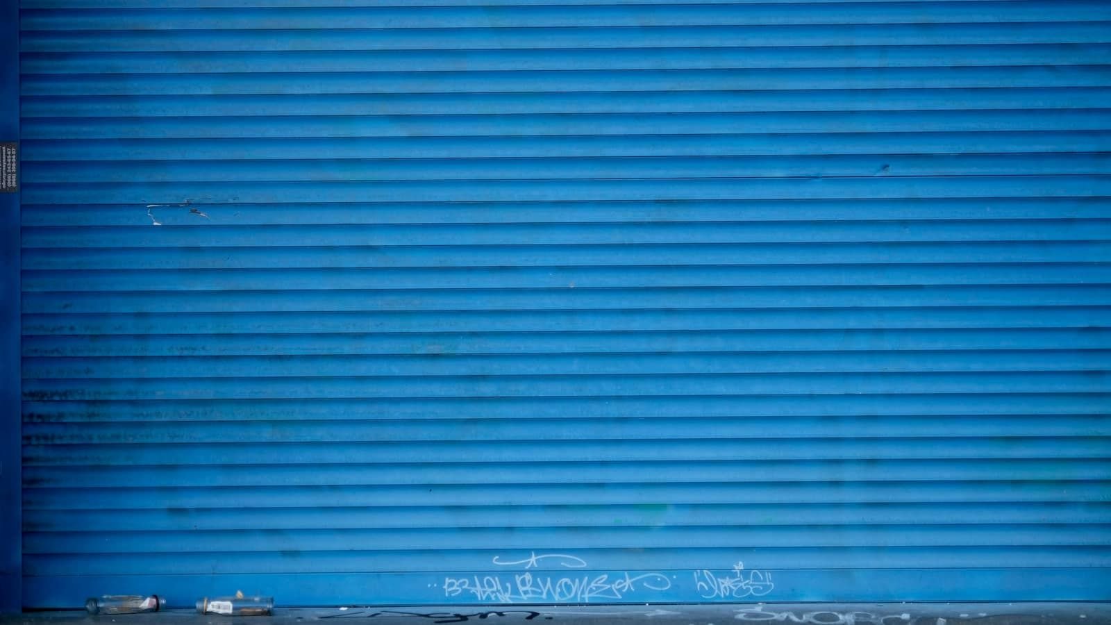A closed blue metal roll-up shutter
