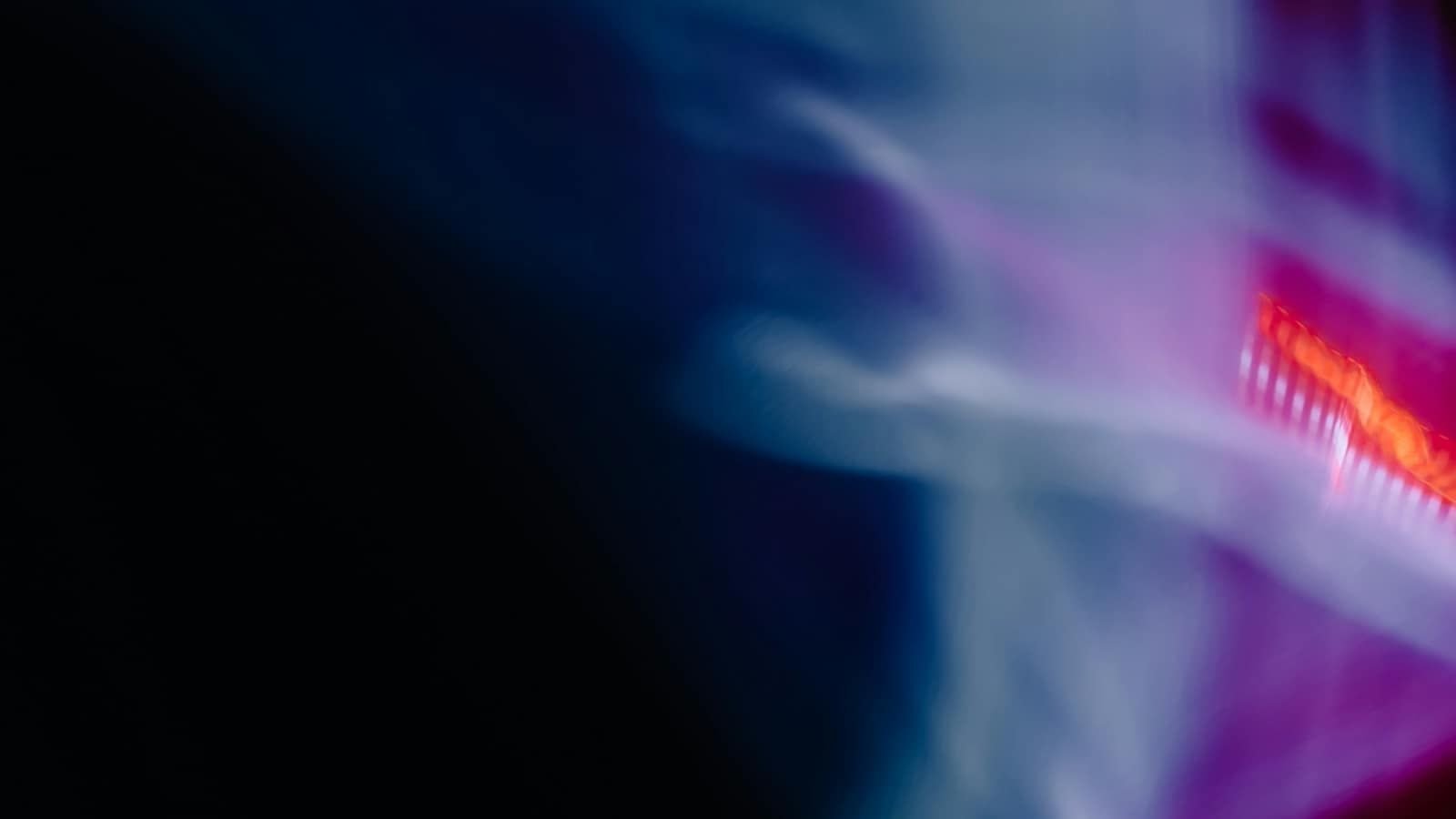 Blurred blue and pink light streaks in a dark room