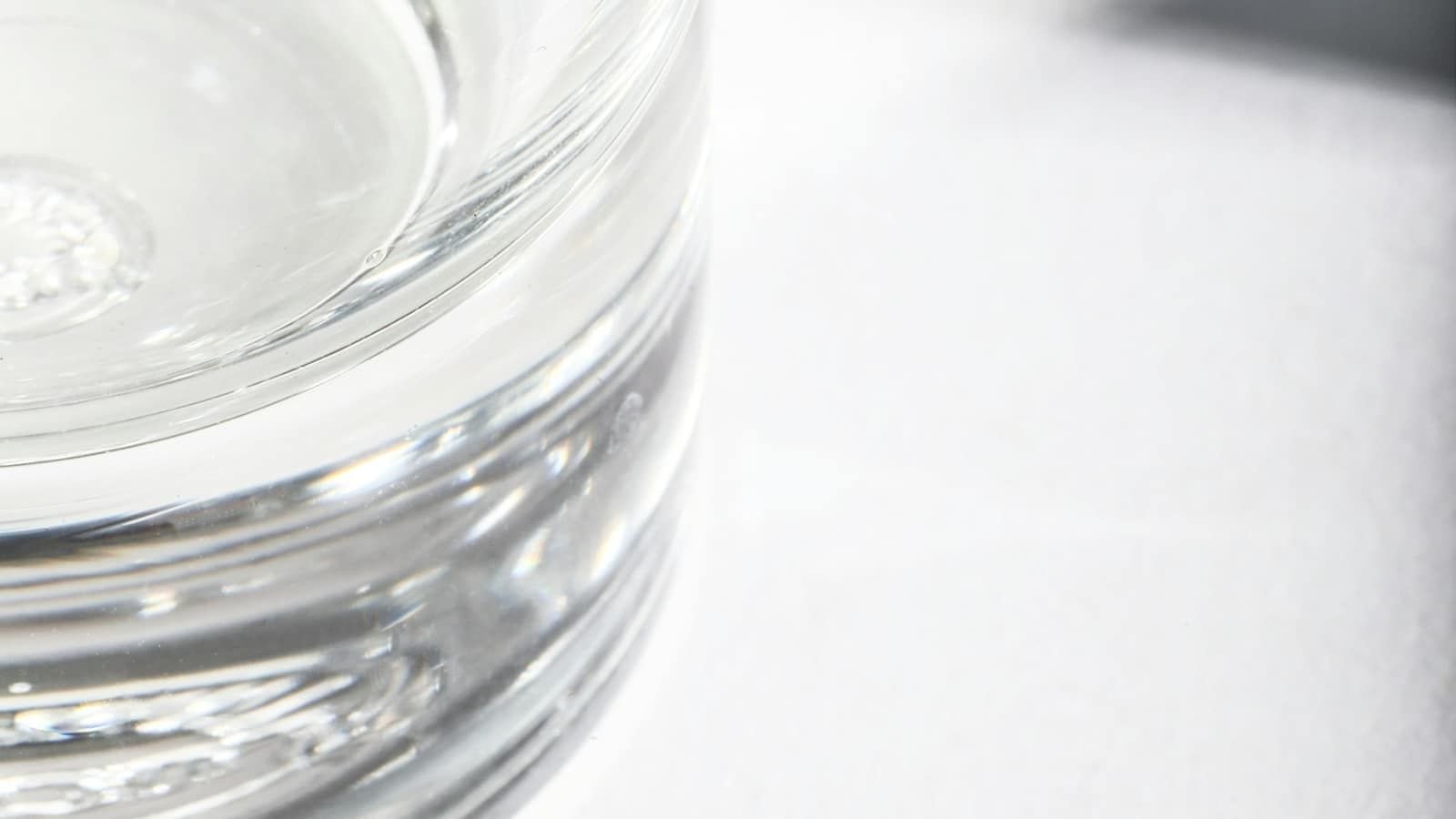 Light reflecting through a thick clear glass on a white surface