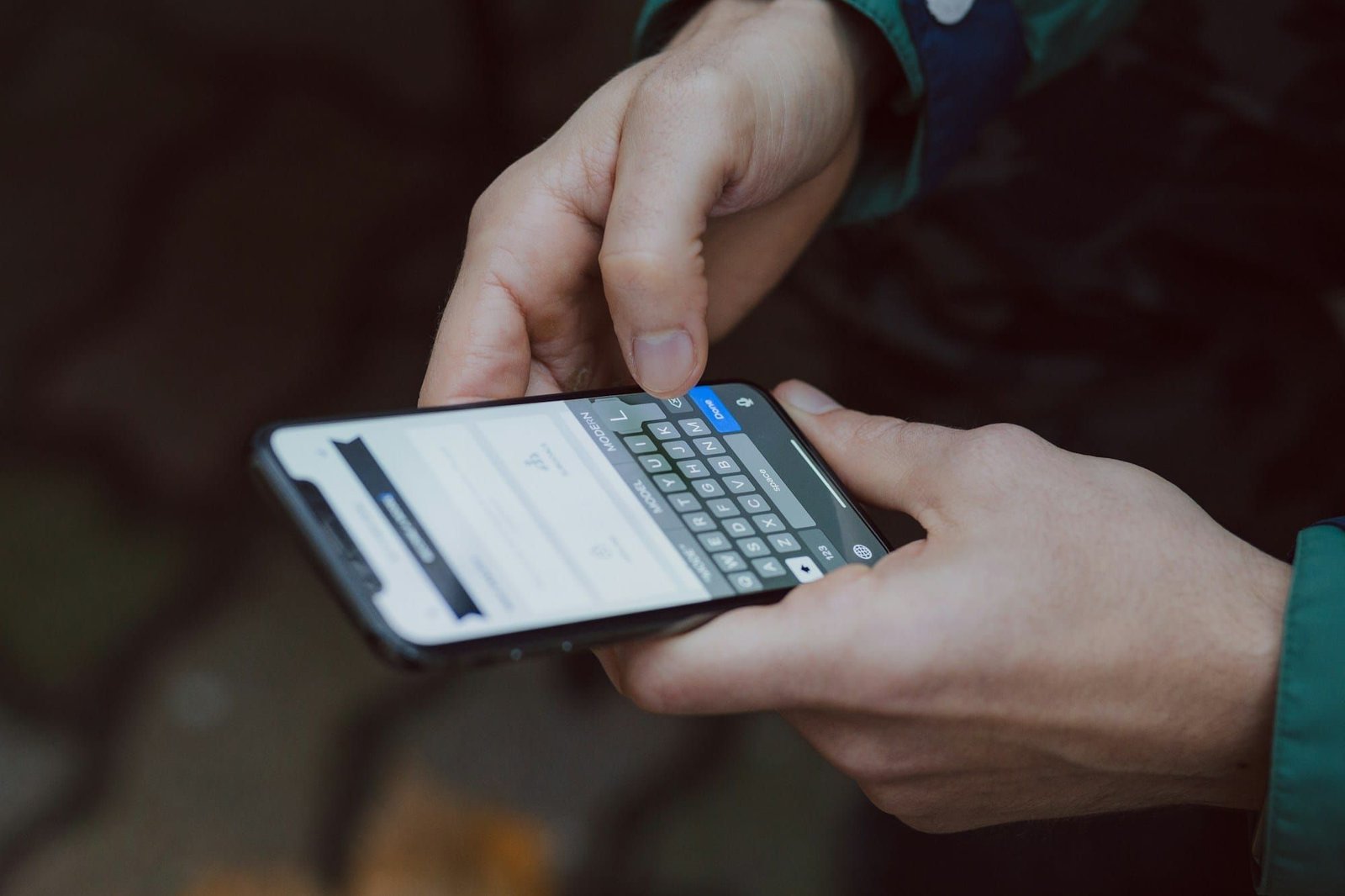 Close-up of two hands typing a message on a smartphone
